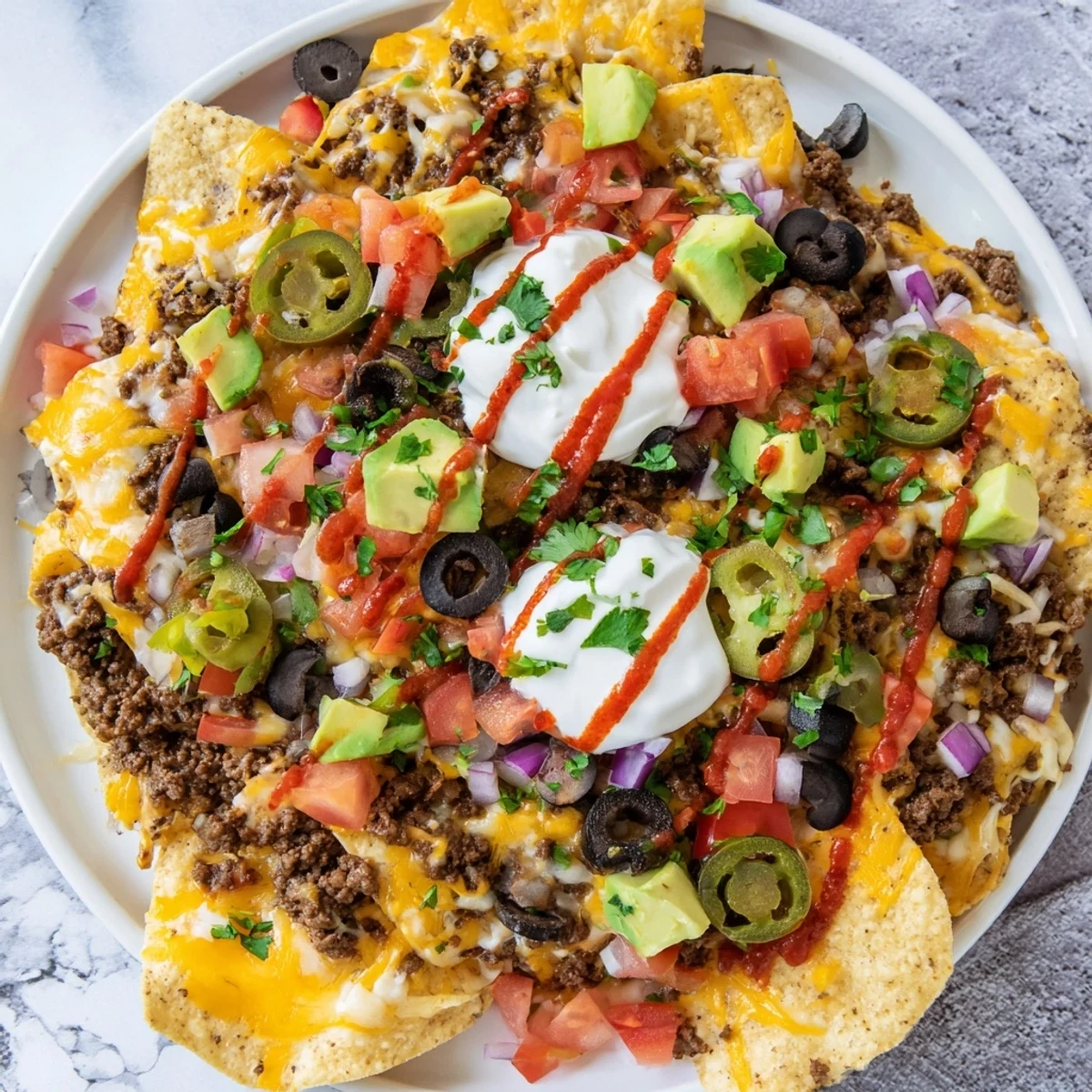 Crispy tortilla chips piled high with beef, cheese, and jalapeños on a Super Bowl nacho platter, ready to enjoy.