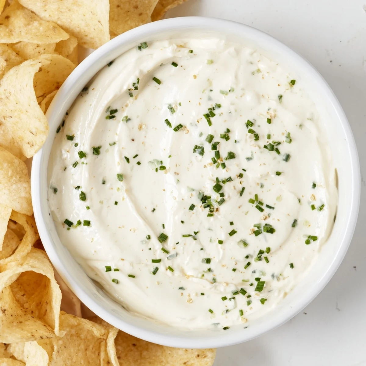 A luscious creamy dip bowl with chips in a rustic setting, ideal for parties and gatherings.