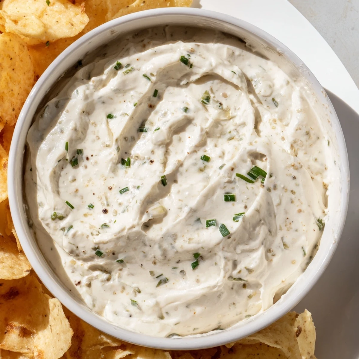 Creamy dip bowl with chips arranged around the dip, perfect for a game-day snack platter.