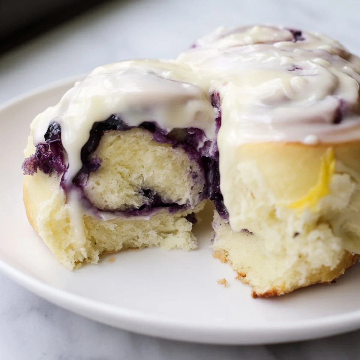 A warm Lemon Blueberry Sweet Rolls with Vanilla Icing served on a white plate, perfect for a cozy breakfast or brunch.