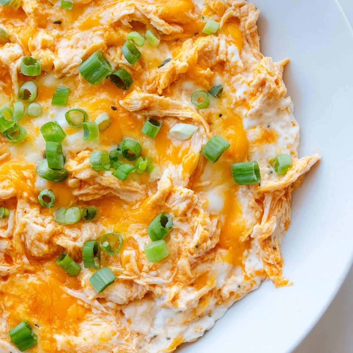 Creamy Spicy Buffalo Chicken Dip with Tortilla Chips is bubbling with melted cheddar and mozzarella, garnished with green onions and served for game day.