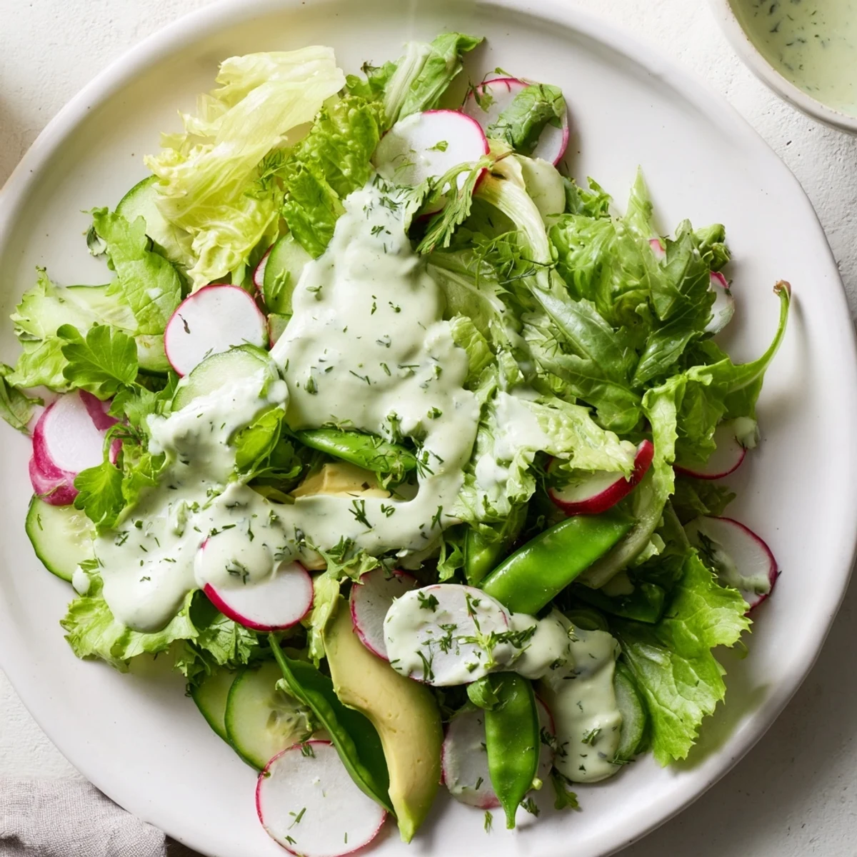A crisp Green Salad with Green Goddess Dressing featuring creamy avocado and crunchy cucumbers.