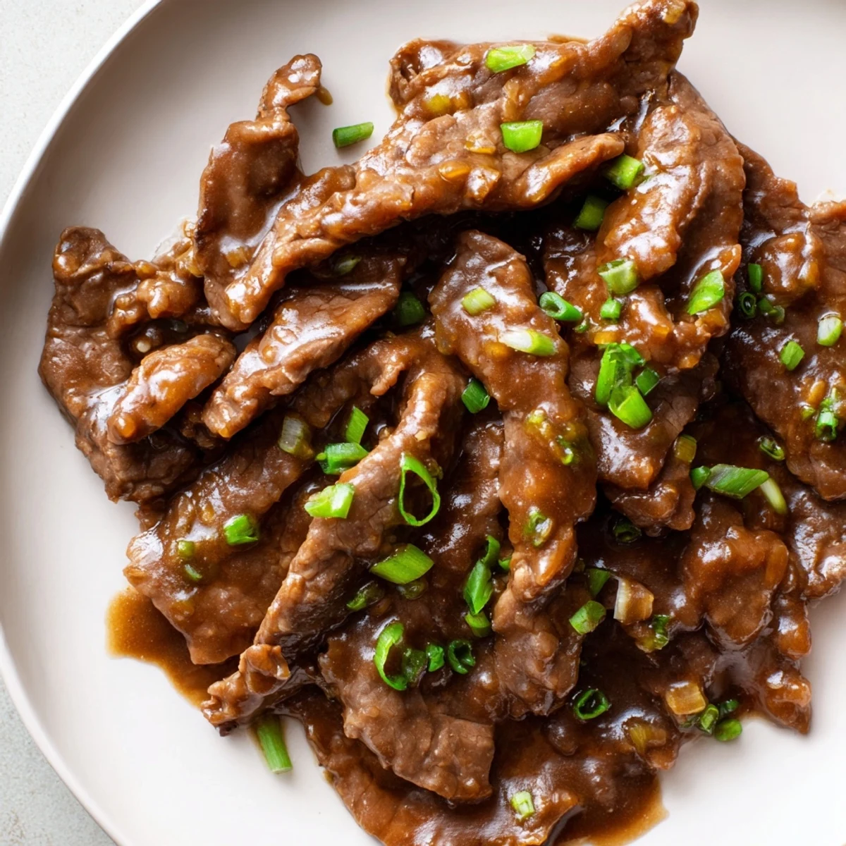 Slow-cooked Ultimate Slow Cooker Mongolian Beef in rich sauce with tender beef, garlic, ginger, and sesame seeds.