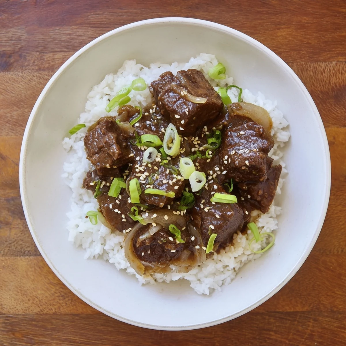 A close-up of glossy Crock Pot Korean Beef in lettuce cups, garnished with green onions and sesame seeds.