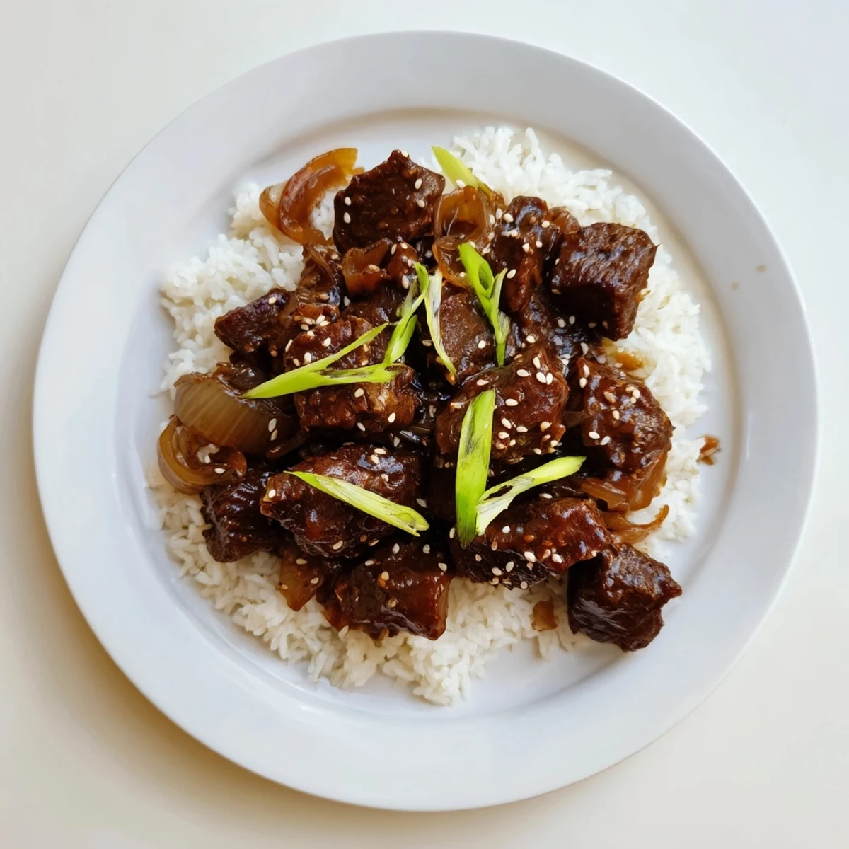 Fork-tender Crock Pot Korean Beef with rich sauce over rice, sprinkled with sesame seeds and sliced green onions.