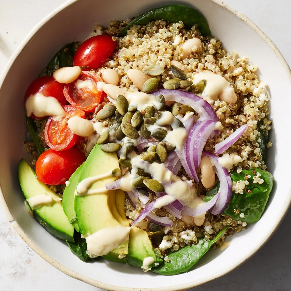 A vibrant bowl of the Spinach & White Bean Ultimate Protein Power Bowl with creamy avocado and quinoa.