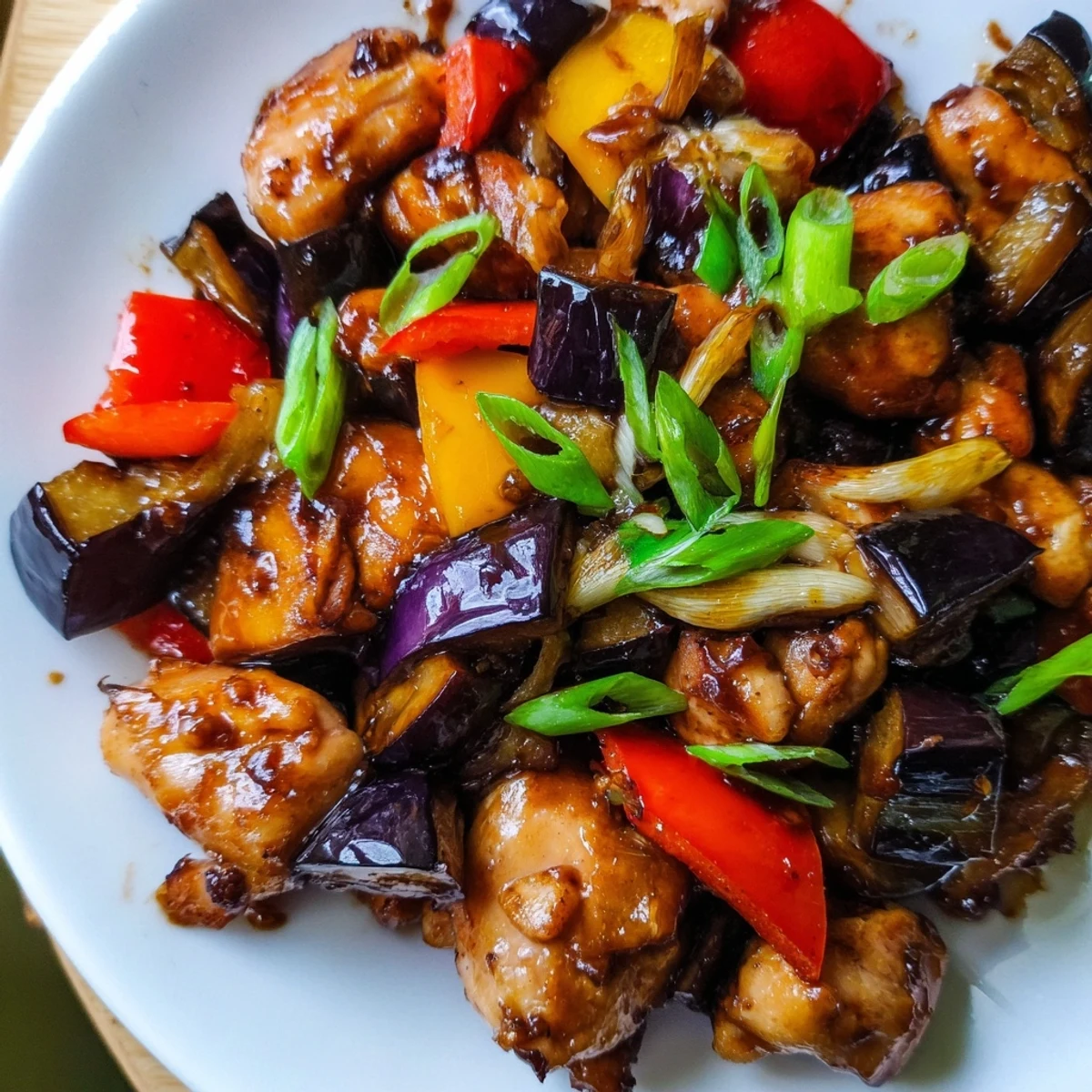Overhead shot of Black Vinegar Chicken With Bell Peppers And Eggplant stir-fry featuring vibrant red and yellow peppers.