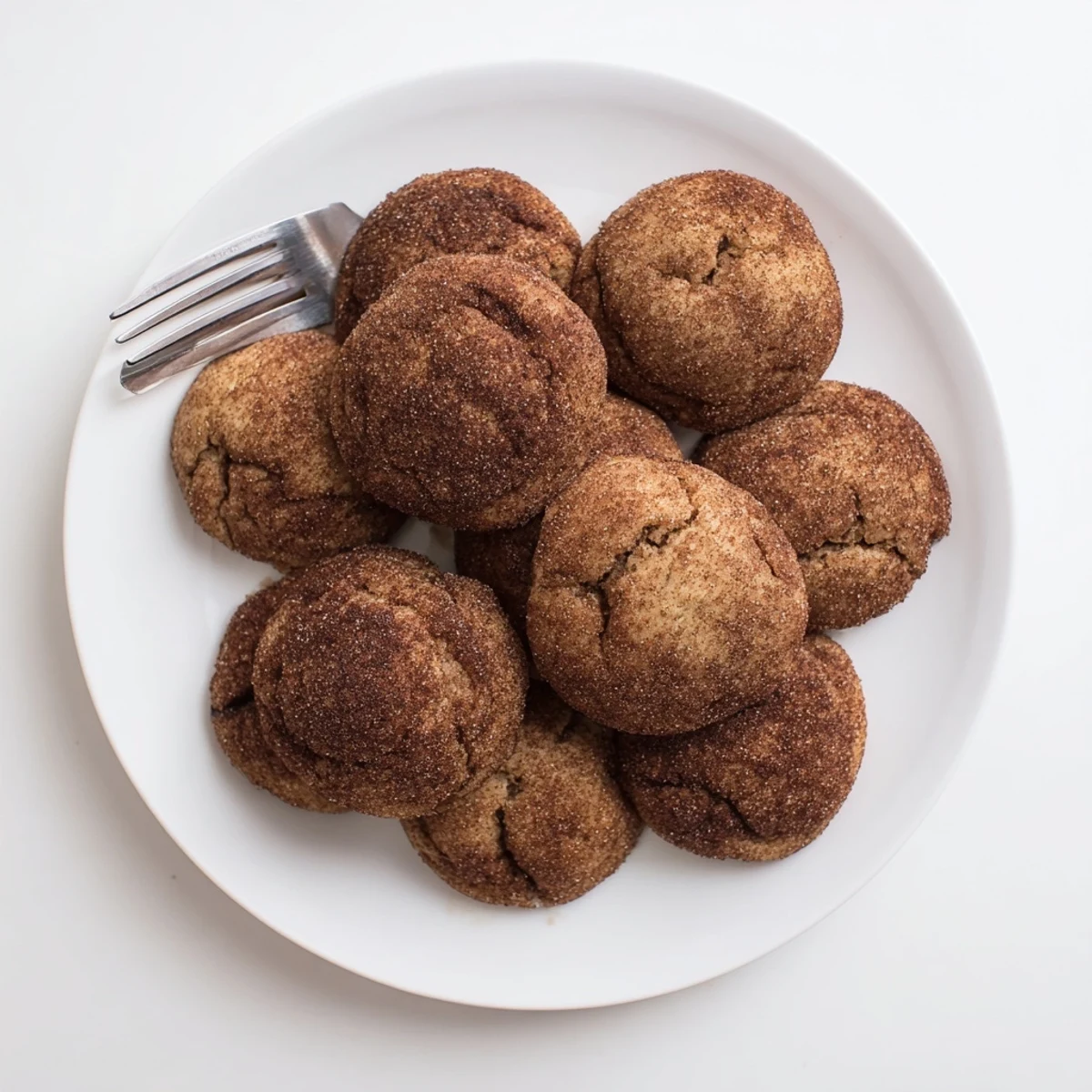 Freshly baked Chocolate Snickerdoodles rest on a cooling rack, their cinnamon-sugar coating visible.