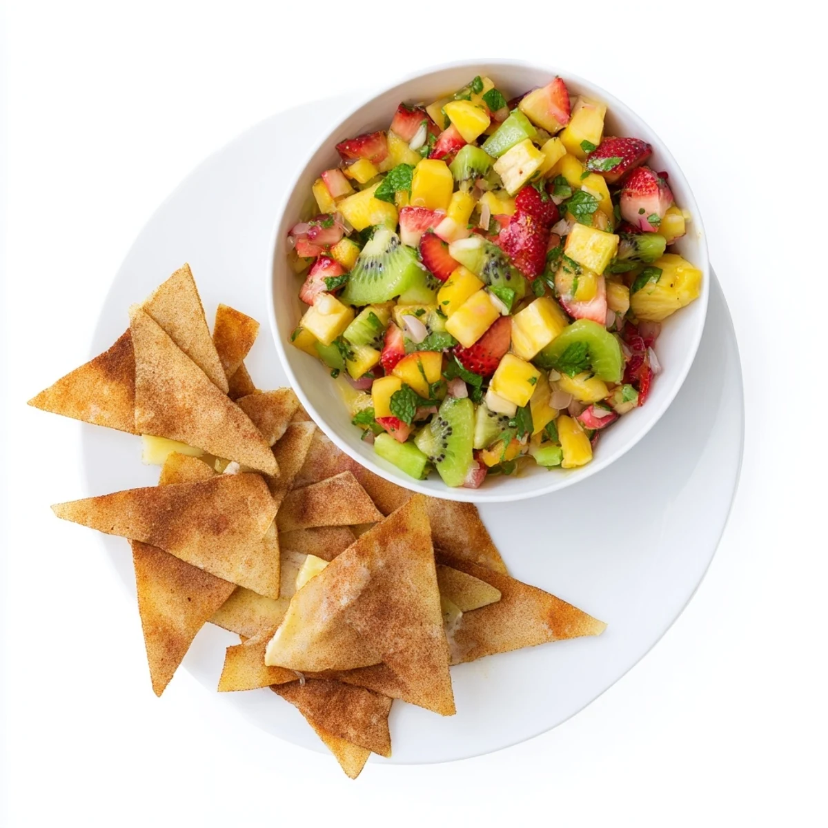 A hand holding a golden-brown cinnamon sugar tortilla chip dipped into a vibrant Fruit Salsa With Cinnamon Sugar Tortilla Chips.
