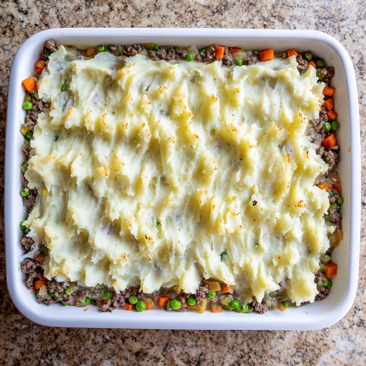 Golden-brown Shepherd's Pie with Creamy Garlic Mashed Potatoes topped with melted cheddar and fresh parsley.