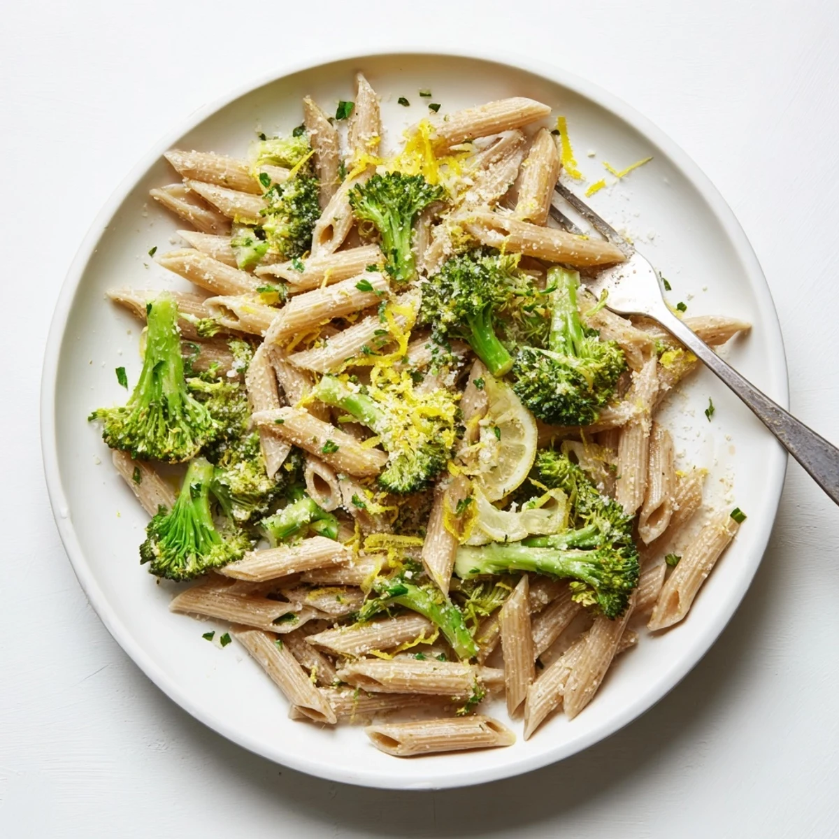 A close-up of Easy Healthy Broccoli Pasta tossed with lemon zest and Parmesan, garnished with red pepper flakes for a zesty kick.