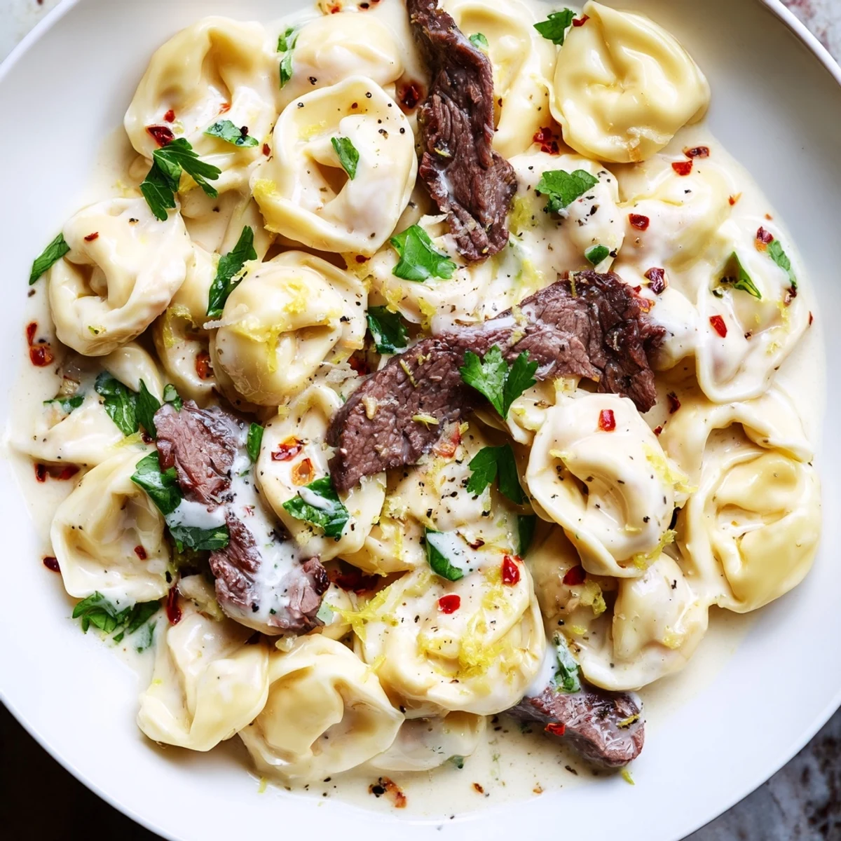 Golden garlic steak tortellini in a velvety cream sauce with fresh parsley garnish