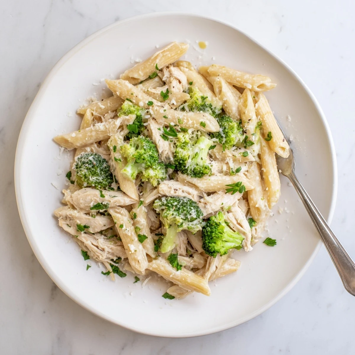 Steaming bowl of rotisserie chicken broccoli pasta with tender penne and parmesan