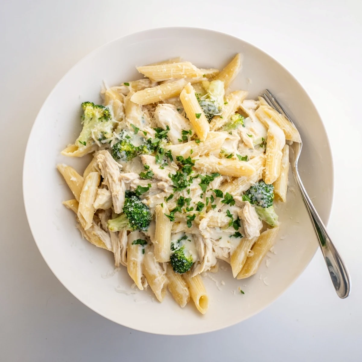 Weeknight dinner featuring rotisserie chicken broccoli pasta tossed in garlic cream sauce