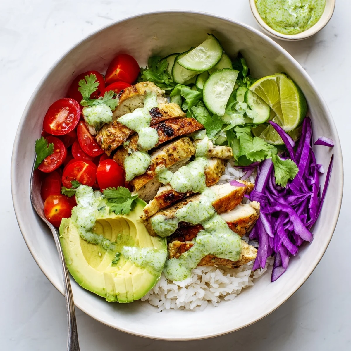 Vibrant chimichurri grilled chicken bowl loaded with grilled chicken breast cherry tomatoes avocado cucumber red cabbage and tangy garlic yogurt sauce