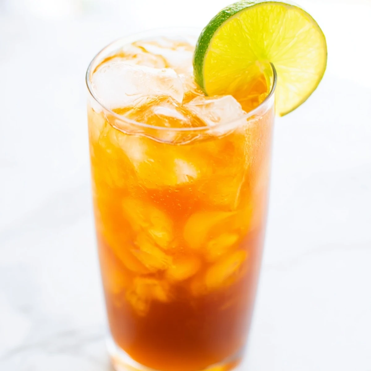 Refreshing Thai lime iced tea with floating lime slices in a tall glass