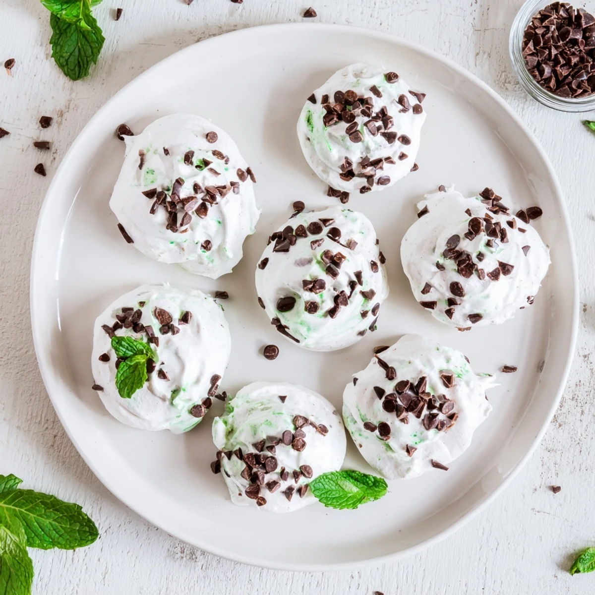 Dreamy dark chocolate and mint chip clouds featuring glossy brown meringues with green mint speckles