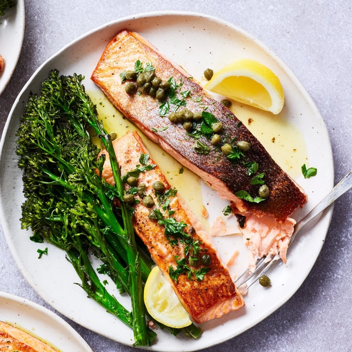 Golden crispy-skinned Gordon Ramsay pan fried salmon with garlic butter sauce and fresh parsley
