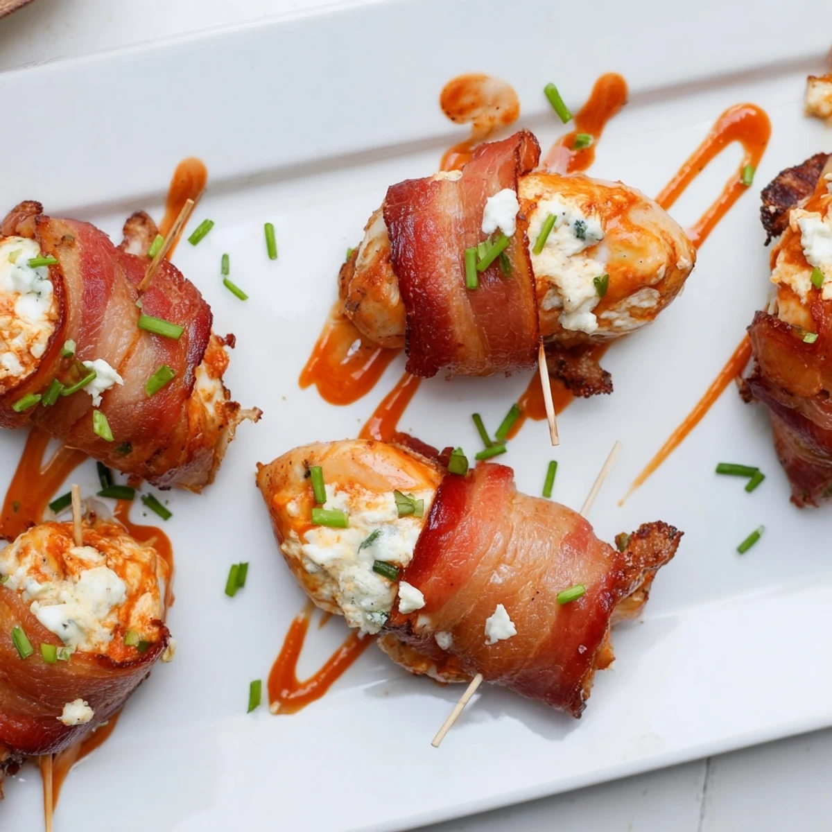 Golden crispy bacon wrapped buffalo chicken bombs oozing with spicy cream cheese filling