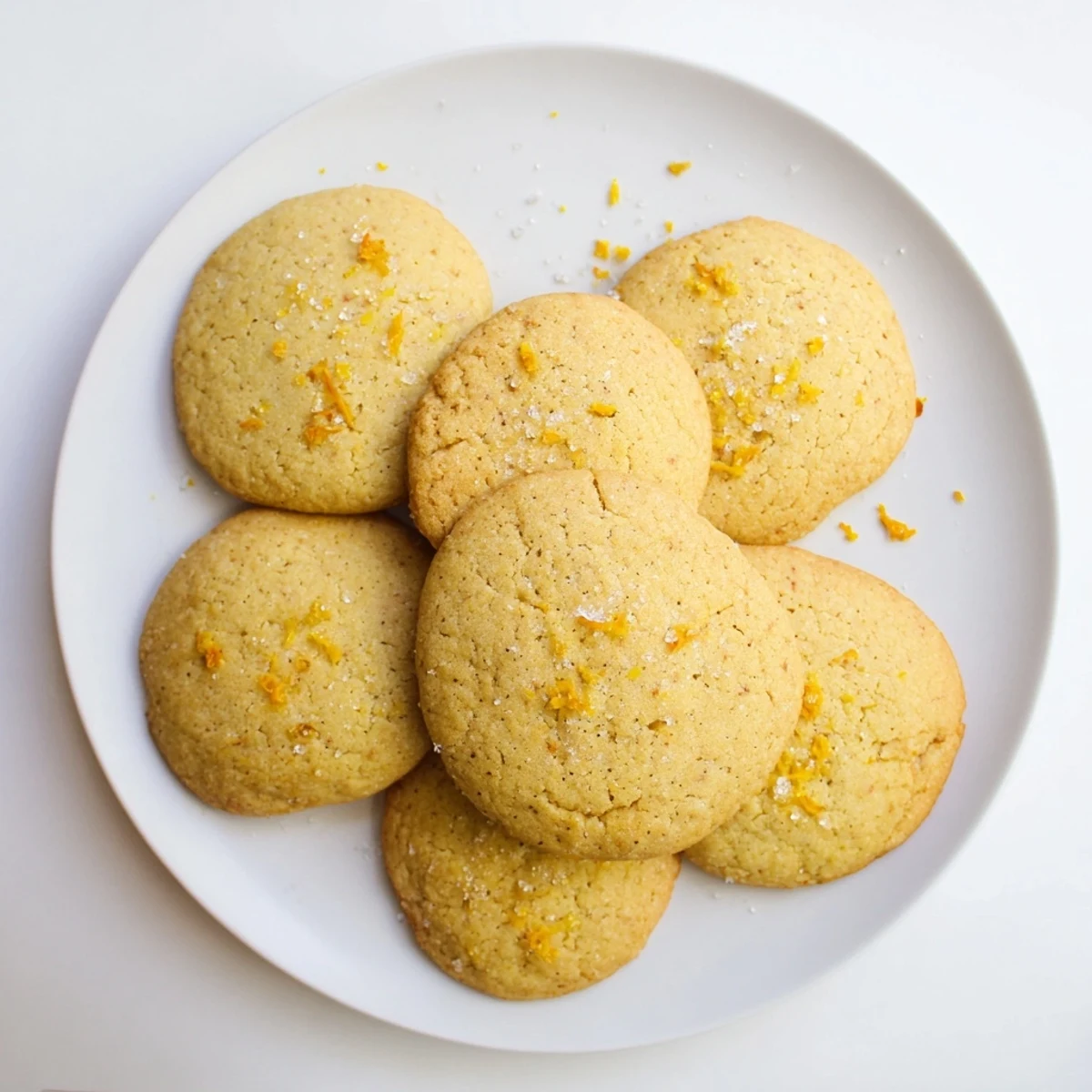 Festive orange clove cookies arranged on a wooden board with tea cups nearby