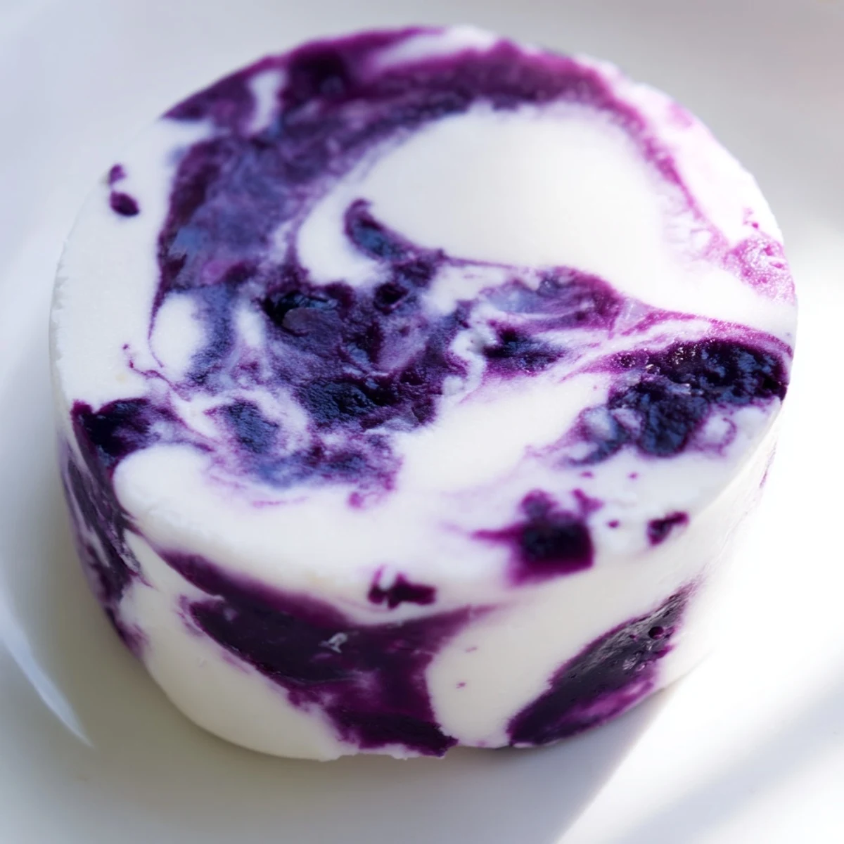 Bite-sized blueberry swirl yogurt treats topped with thick berry compote ready for freezing