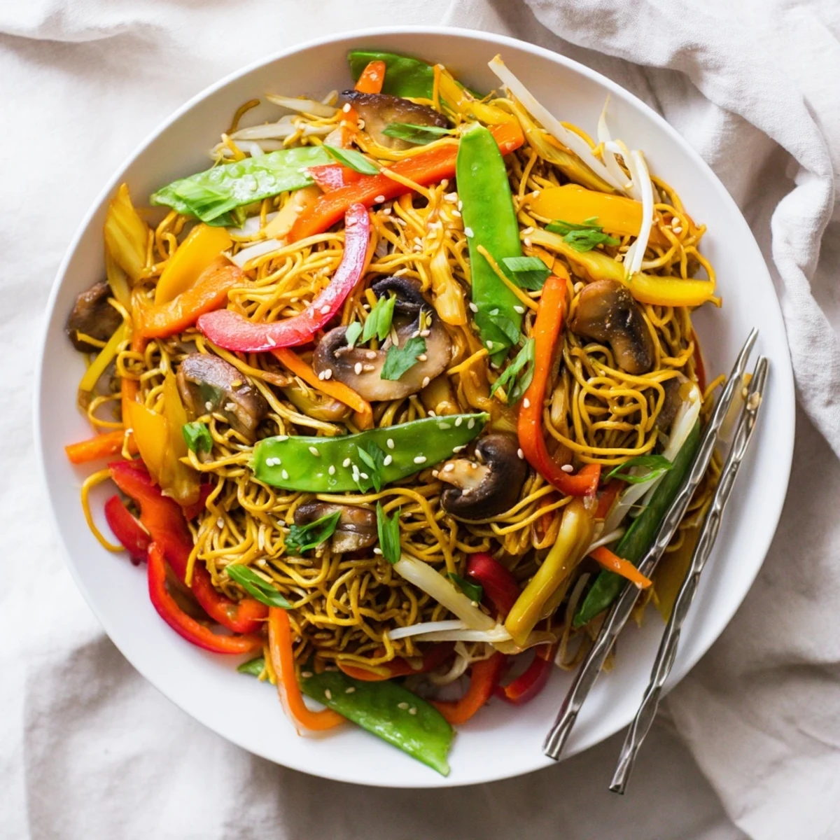 Golden crispy noodle chow mein topped with colorful stir-fried vegetables in savory brown sauce