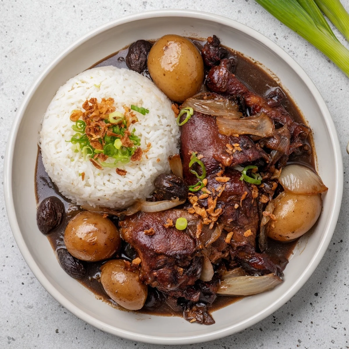 Braised chicken thighs in tangy soy vinegar sauce garnished with fried garlic