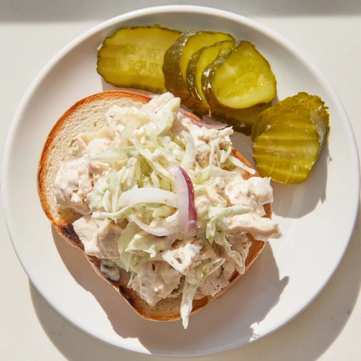Tender smoked chicken dripping with tangy Alabama white BBQ sauce topped with crunchy coleslaw on warm sandwich bun