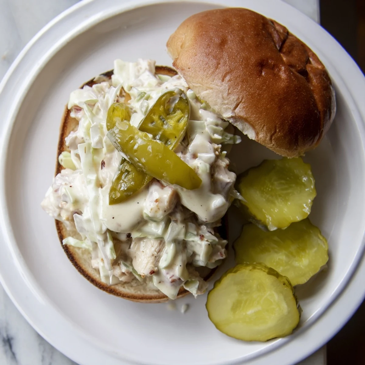Golden Alabama BBQ chicken chopped sandwich piled high with creamy white sauce and crisp slaw on toasted bun