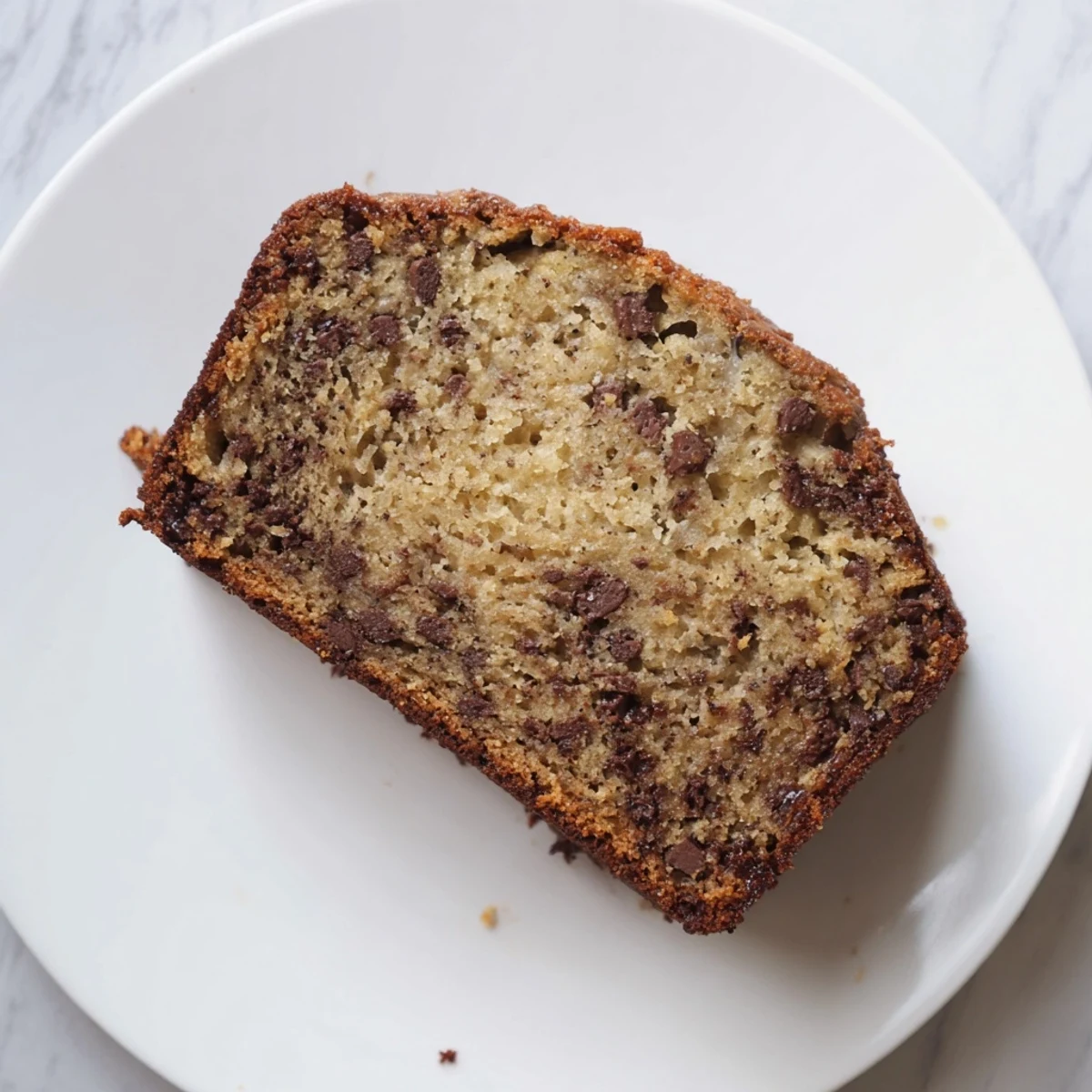 Freshly baked chocolate chip banana bread cooling on a wire rack with golden crust