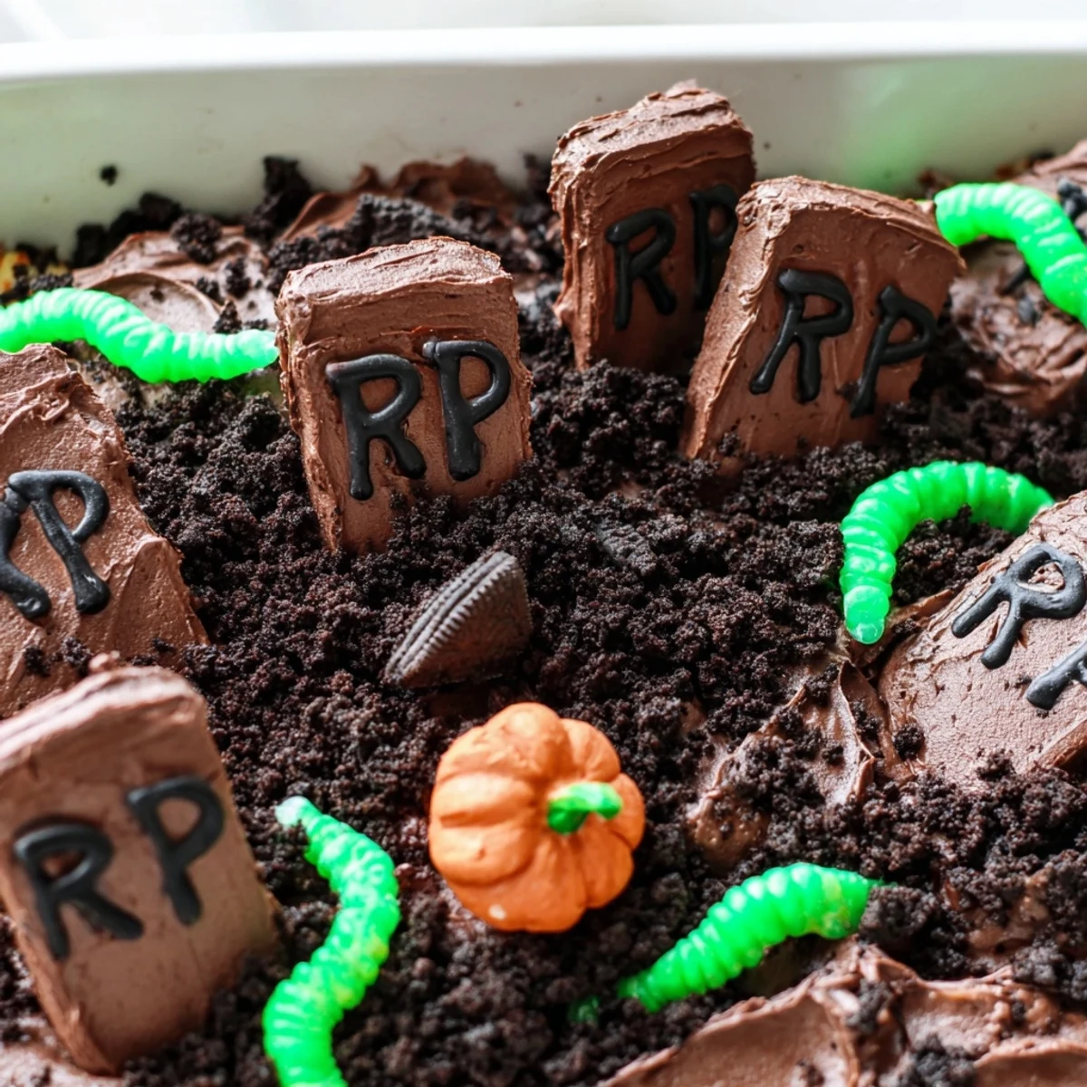 Frosted Pull Apart Graveyard Cupcakes decorated with cookie tombstones and candy worms on a tray