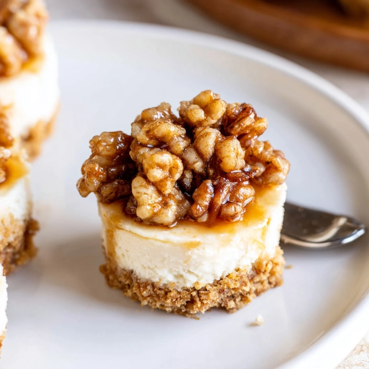 Warm pecan drizzle over Mini Pecan Pie Cheesecakes served with whipped cream