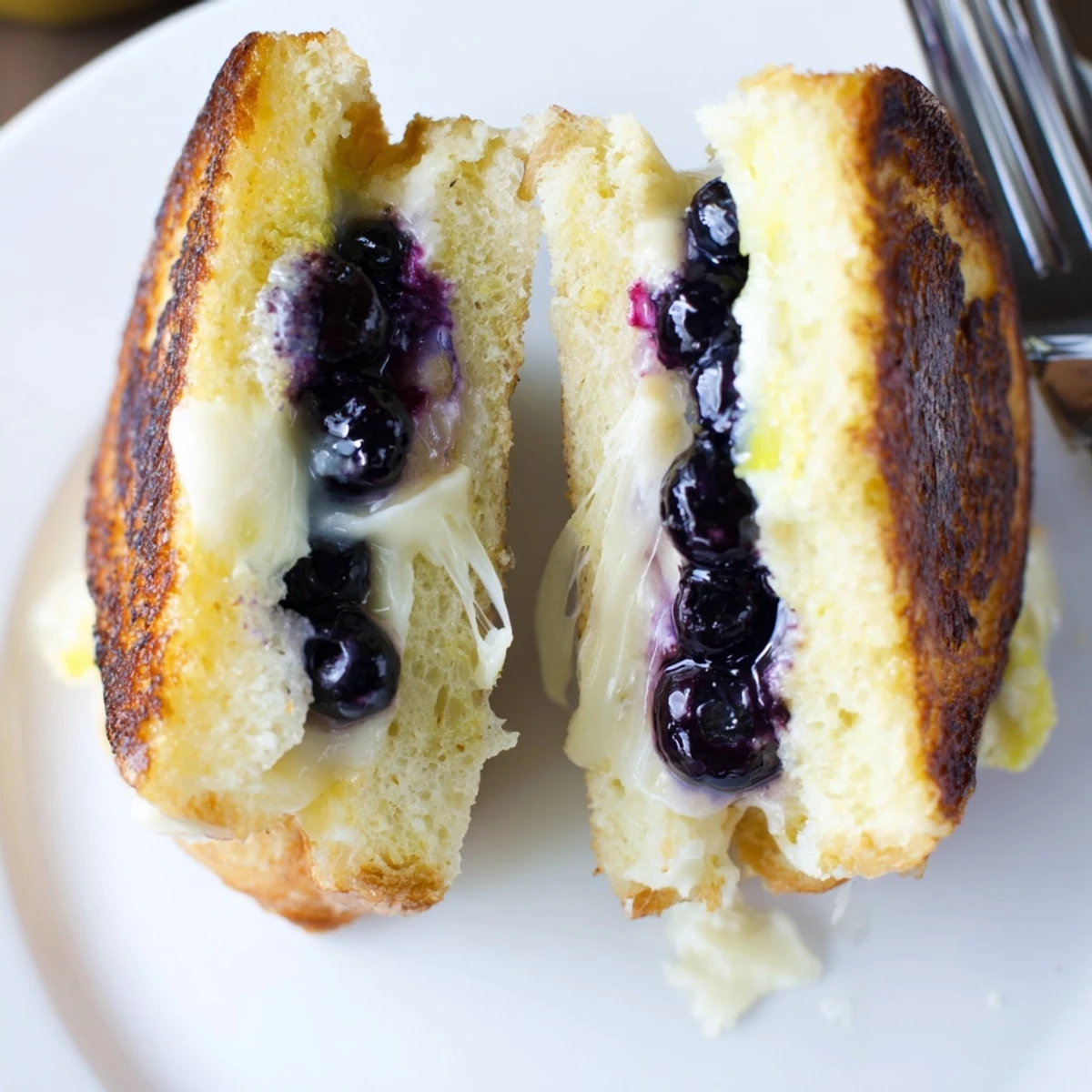 Juicy Blueberry Grilled Cheese sliced, steam rising, paired with tomato soup