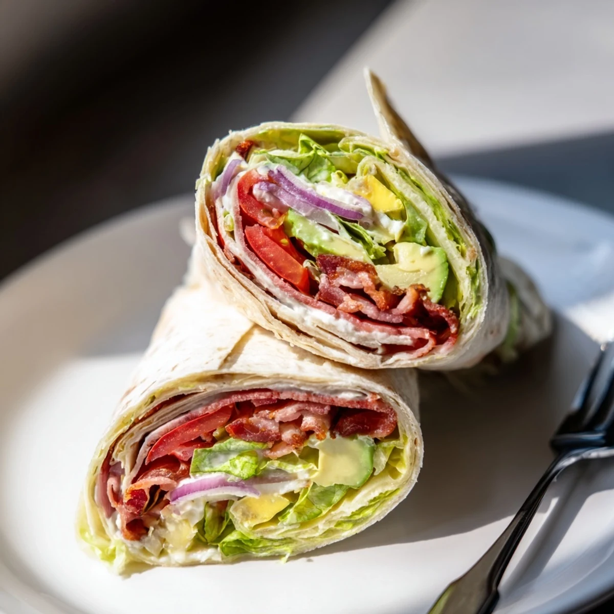 Sliced Meal Prep BLT Wraps showing creamy dressing, crunchy lettuce, ripe tomato