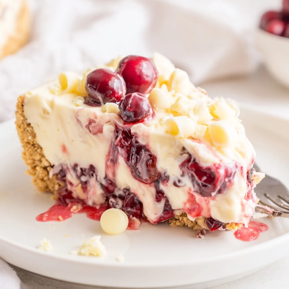 Sliced No Bake Cranberry White Chocolate Cheesecake on plate, zesty lemon hints