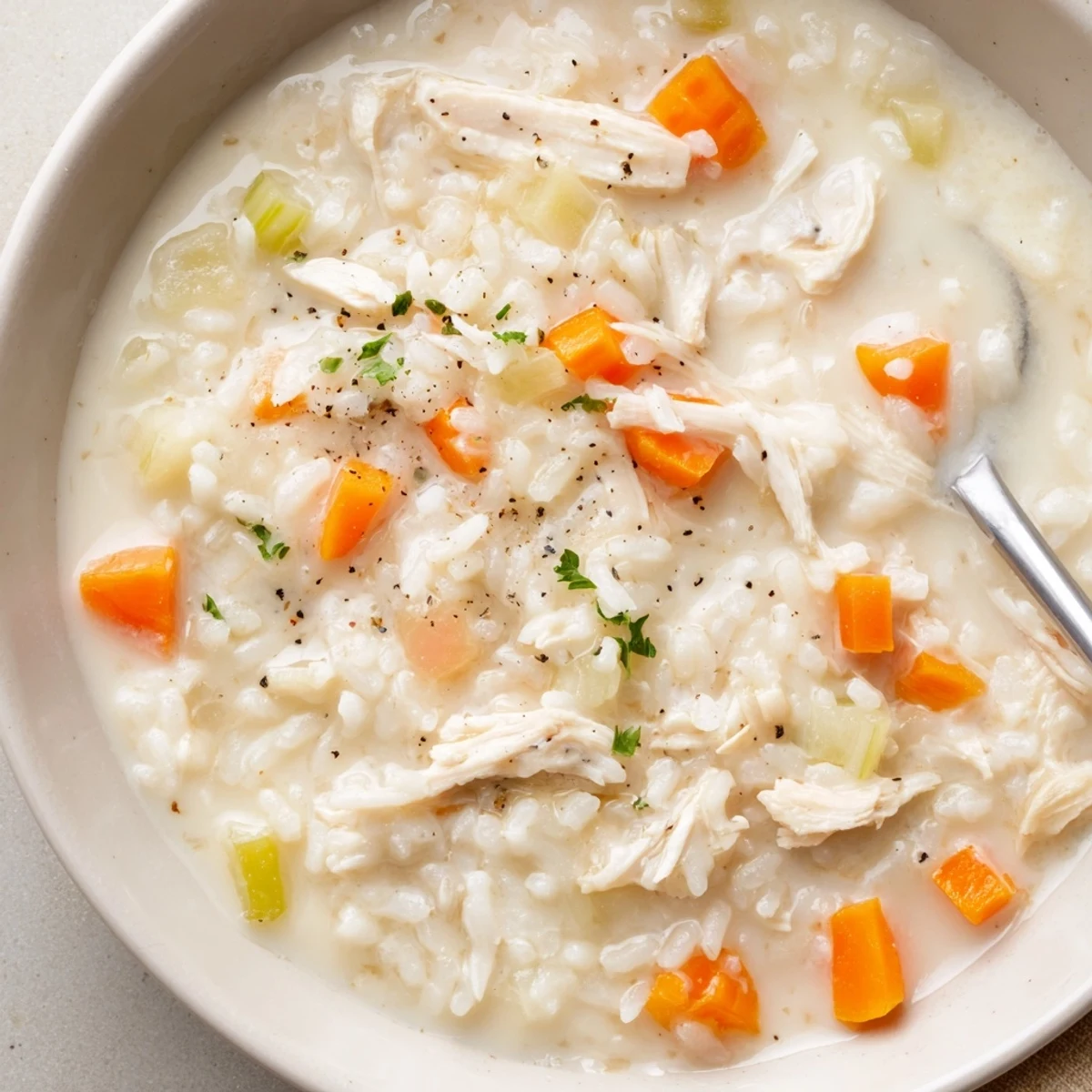 Bowl of Creamy Chicken Rice Soup served with crusty bread and parsley