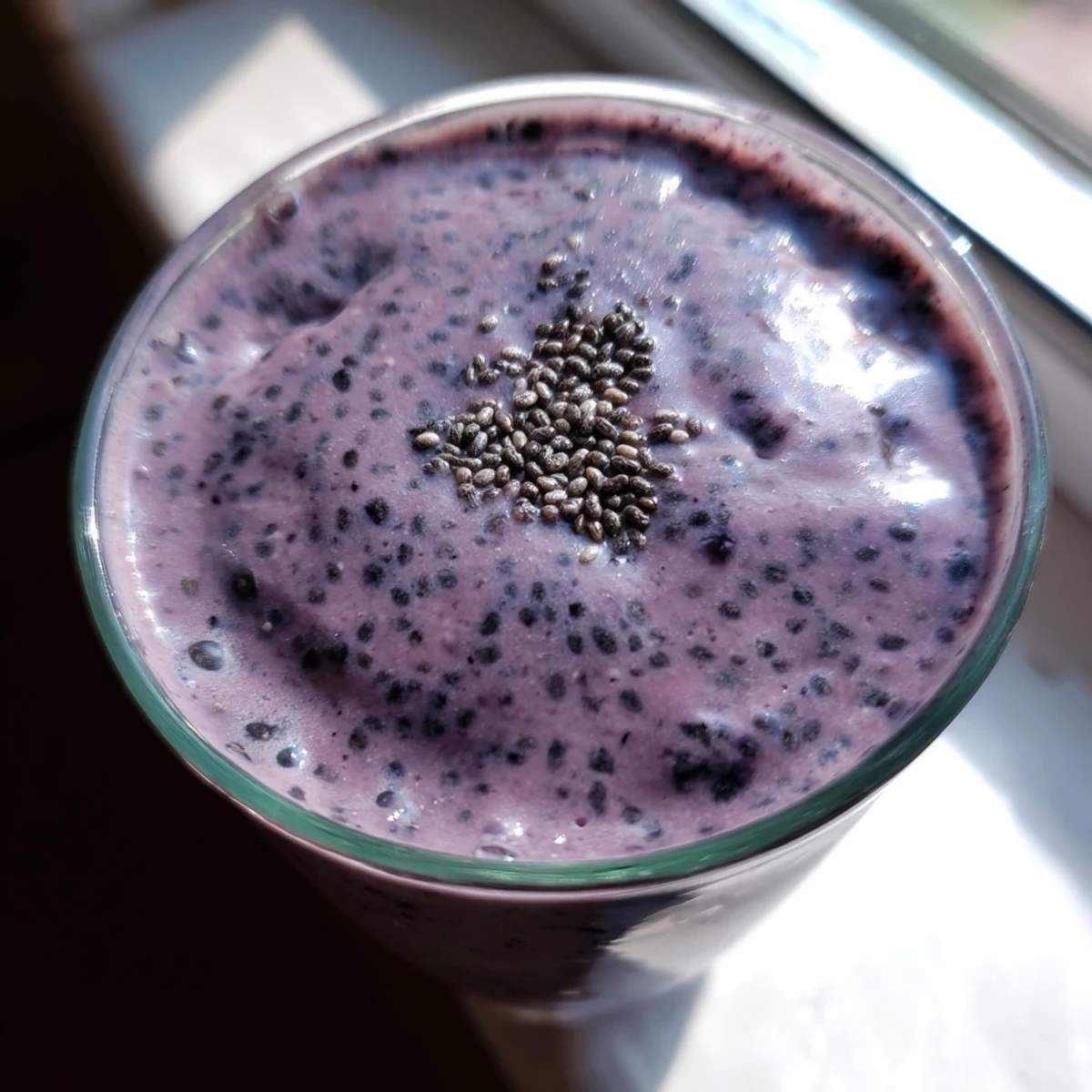 Creamy chia seed smoothie blended with banana and mixed berries poured into two glasses