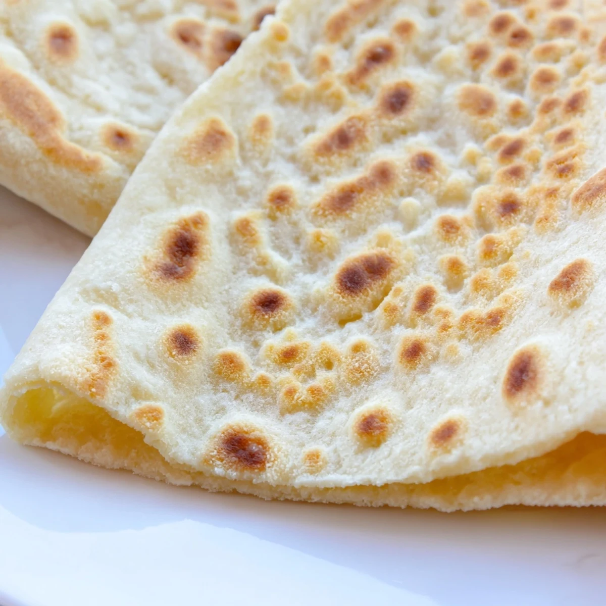 Soft Turkish Bazlama bread stacked warm, brushed with melted butter for serving