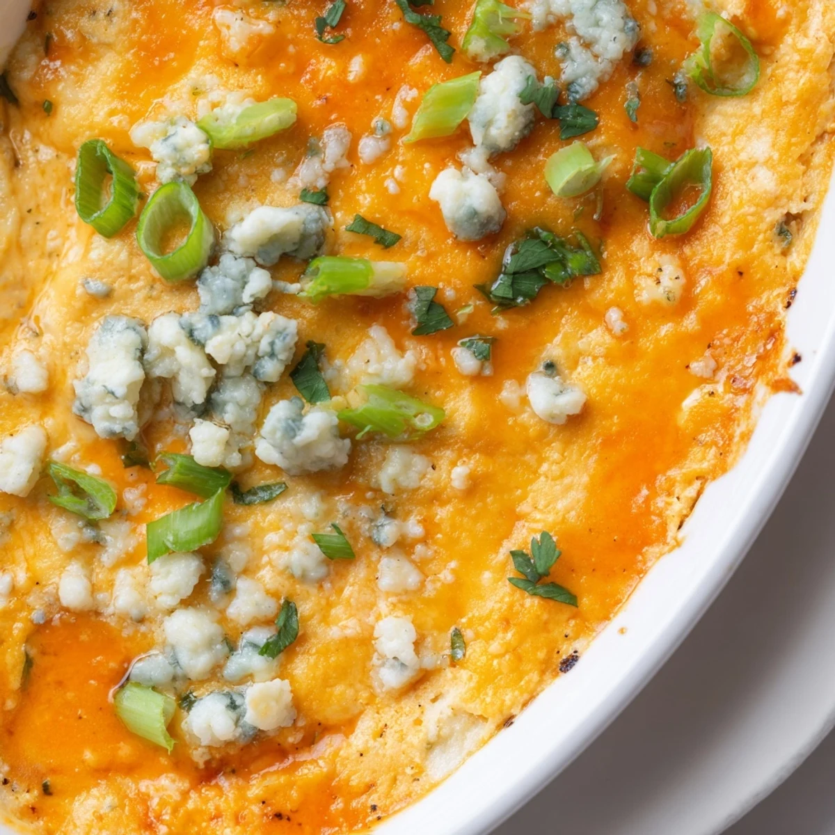 Creamy white bean buffalo dip appetizer sprinkled with fresh green onions and parsley