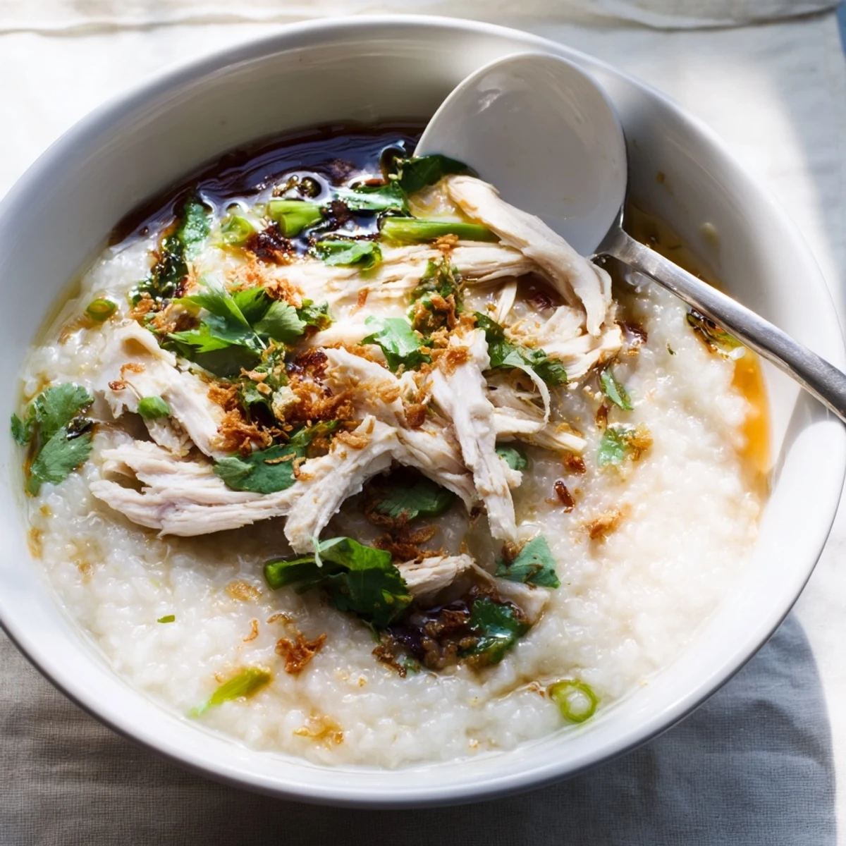 Savory rice porridge with shredded chicken ginger and optional century egg slices