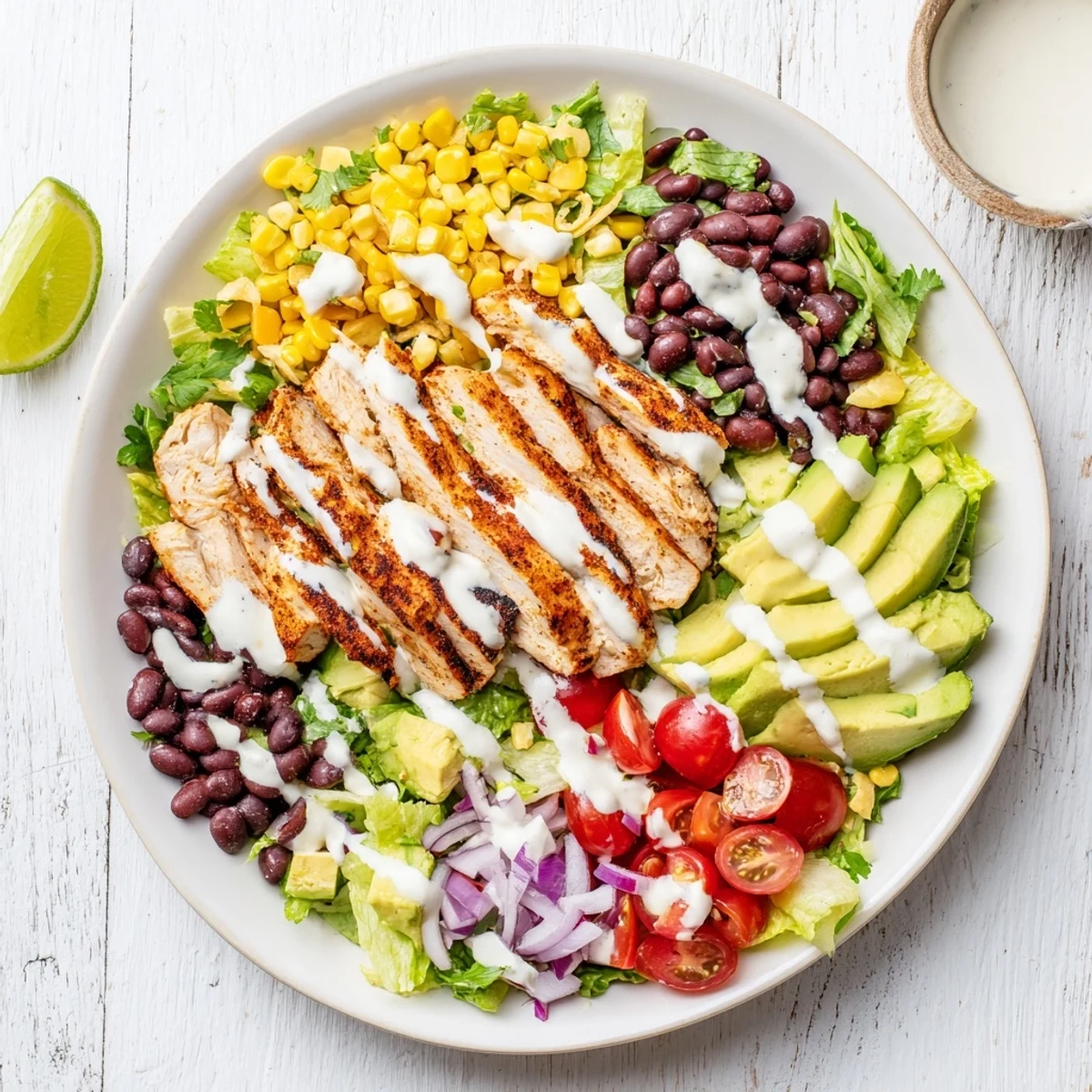 Vibrant salad plate featuring spiced grilled chicken over crisp romaine, avocado, tomatoes, and zesty yogurt dressing
