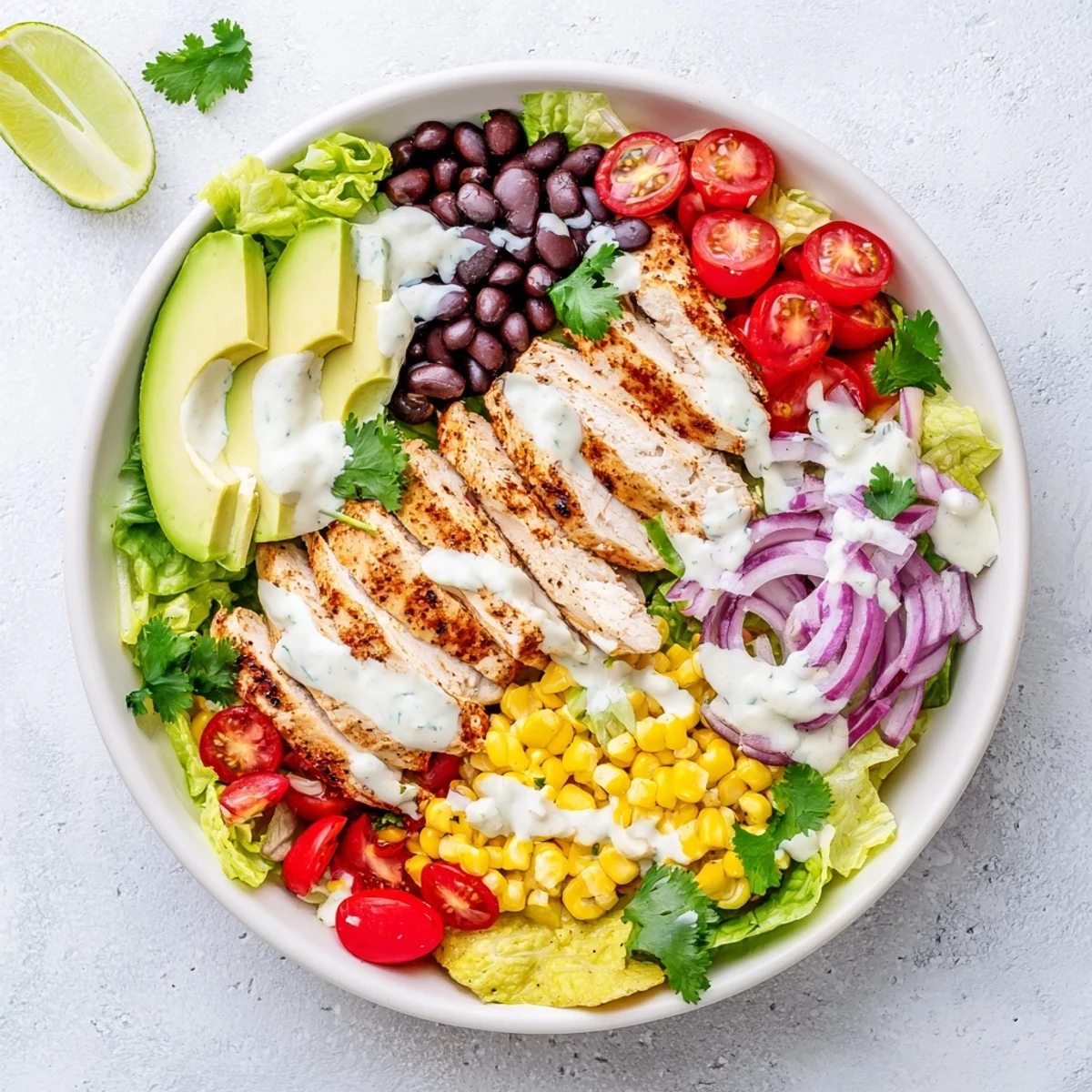 Hearty Southwestern chicken salad with sliced seasoned chicken breast, colorful vegetables, beans, and tangy lime dressing