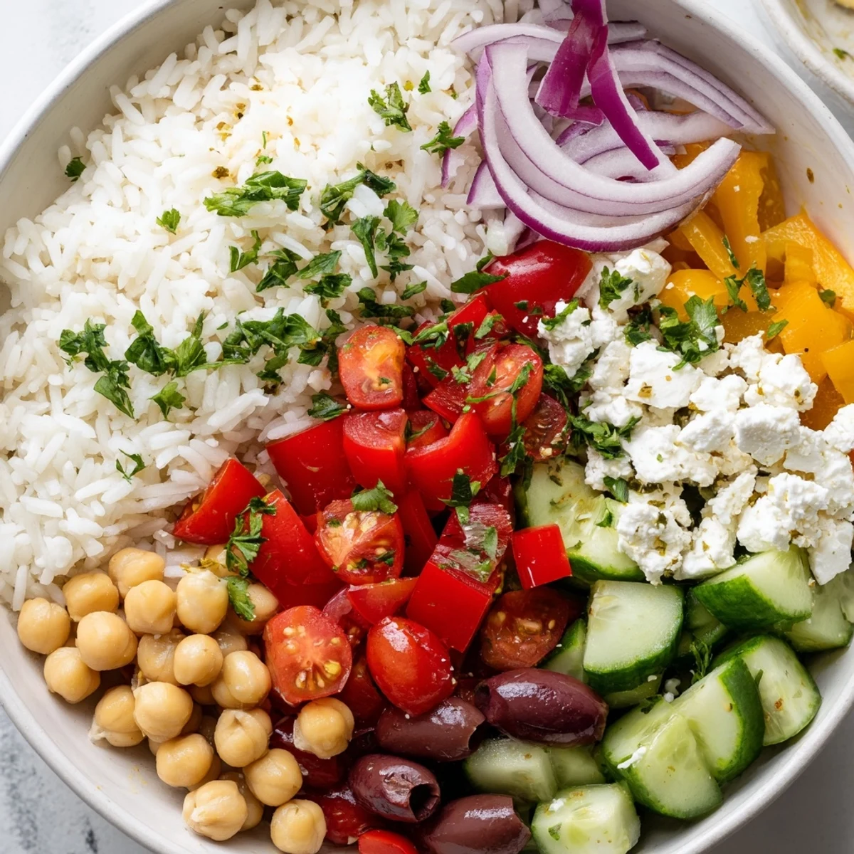 Steaming Mediterranean Rice Bowl drizzled with lemon herb dressing alongside fresh chopped vegetables