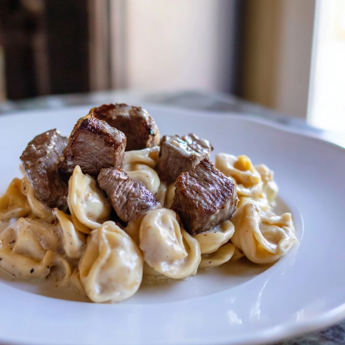 Savory garlic steak tortellini in a rich cream sauce with fresh parsley garnish