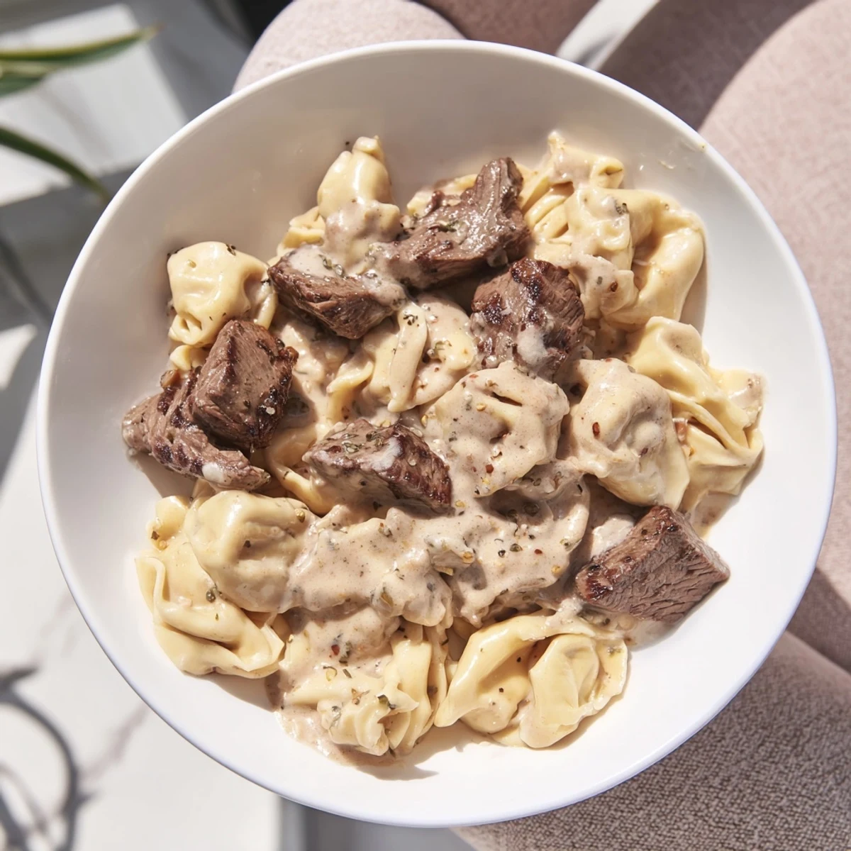 Tender steak bites and cheesy tortellini tossed in a savory garlic cream sauce