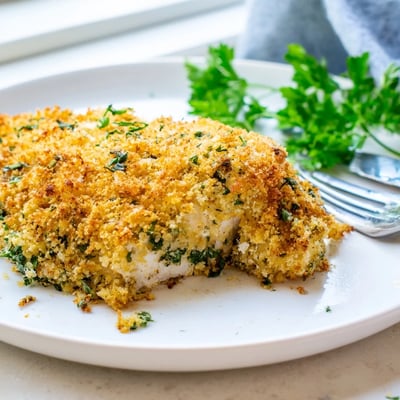 Juicy Savory Herbed Parmesan Chicken sliced open revealing tender meat with a crispy herb crust