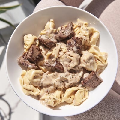 Tender steak bites and cheesy tortellini tossed in a savory garlic cream sauce